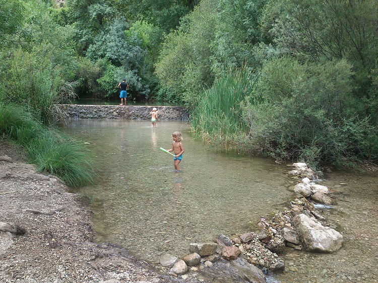 Kinderen spelen in het lage water bij El Burgo